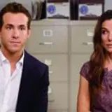 Ryan Reynolds i Sandra Bullock, gwiazdy filmu "Narzeczony mimo woli", siedzą obok siebie w biurze.