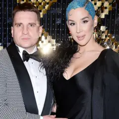 Para z błyszczącymi niebieskimi włosami i mężczyzna w garniturze. Ciekawe, ile lat ma tygrysek Lil Masti?
