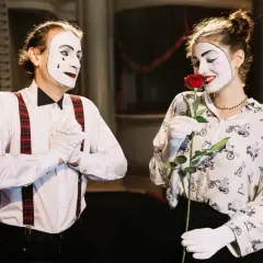 Dwoje mimów w białych rękawiczkach, jeden z łzą na policzku, drugi wącha różę. Inspiracja dla tych, jak zostać aktorem bez szkoły.