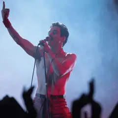 Rami Malek jako Freddie Mercury śpiewa w "Bohemian Rhapsody", porywając tłum gestem i głosem.