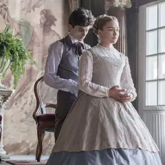 Małe kobietki obsada: Timothée Chalamet i Florence Pugh w strojach z epoki, w eleganckim wnętrzu.