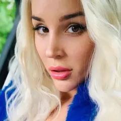 Blondynka w niebieskim futrze, zmysłowe spojrzenie. Ile lat ma sexmasterka? Trudno zgadnąć, wygląda młodo i pięknie.