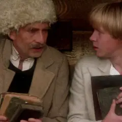Starszą postać w czapce z futra i młodzieńca z książkami, w scenie nad Niemnem, obsada filmu.