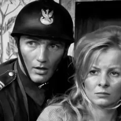 Zbliżenie na twarze aktora w hełmie i aktorki. Scena z filmu "Polskie drogi" z udziałem niezapomnianej obsady.