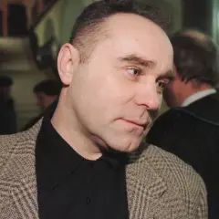 Mężczyzna w tweedowej marynarce, jak zostałem gangsterem o kim, w tle prawnik w todze.