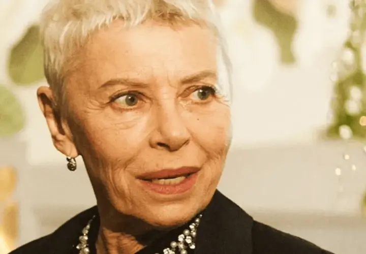Kobieta z krótkimi siwymi włosami, w czarnej bluzce z perełkami, opowiada o tym, jak zostać aktorką.
