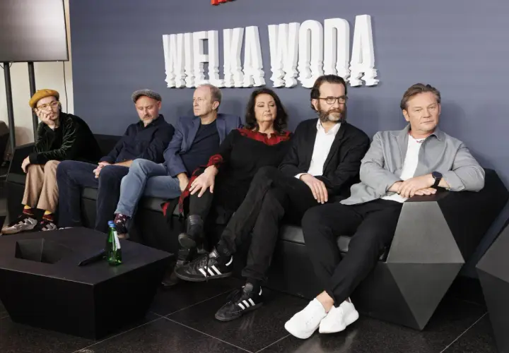 Wielka woda obsada siedzi na kanapie. W tle biały napis "WIELKA WODA".