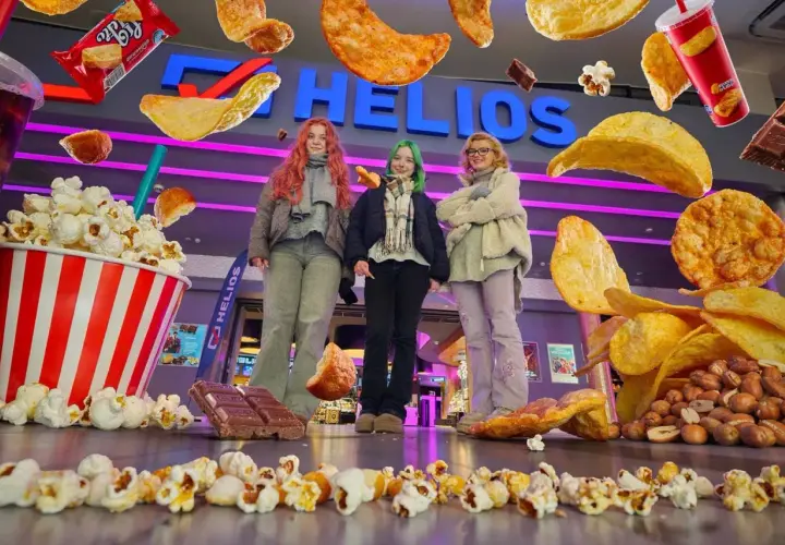 Trzy dziewczyny przed kinem Helios, otoczone przez gigantyczne przekąski. Zastanawiasz się, ile kosztuje mały popcorn w Heliosie?