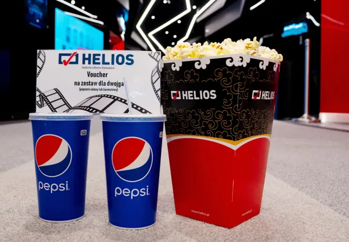 Duży popcorn Helios i dwa napoje Pepsi. Zastanawiasz się, ile kosztuje duży popcorn Helios? Ten zestaw dla dwojga z voucherem to świetna opcja.