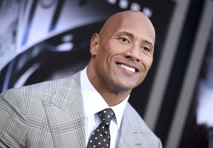 Uśmiechnięty Dwayne Johnson w garniturze. Ciekawe, ile lat ma Dwayne Johnson, patrząc na jego energię!