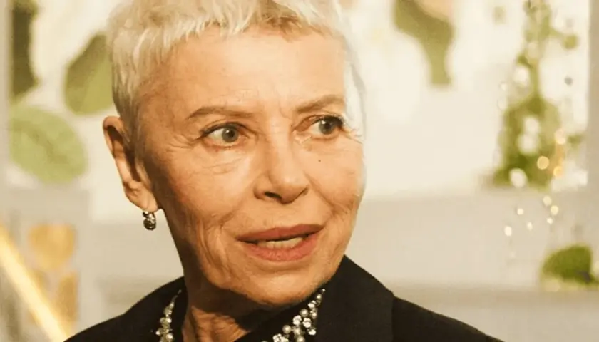 Kobieta z krótkimi siwymi włosami, w czarnej bluzce z perełkami, opowiada o tym, jak zostać aktorką.