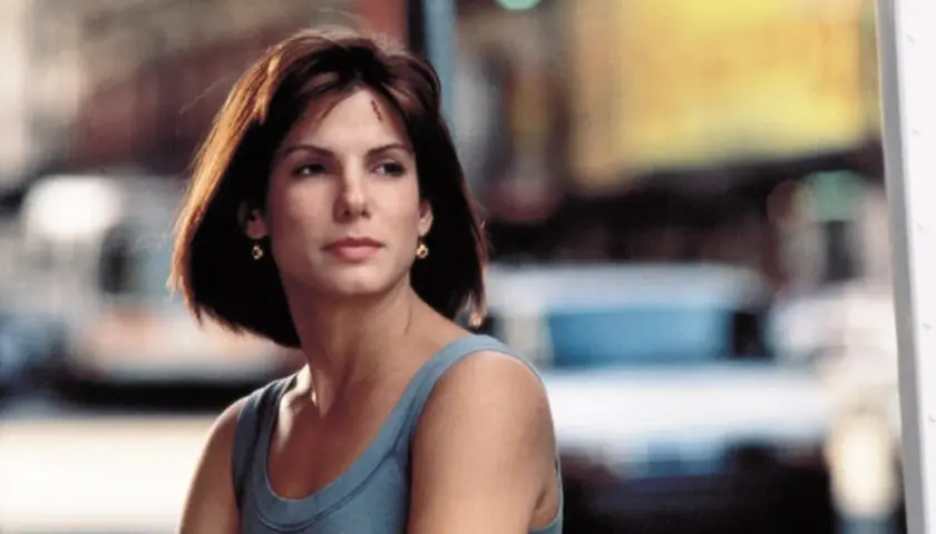 Sandra Bullock w niebieskiej sukience, zastanawia się, ile ma lat.