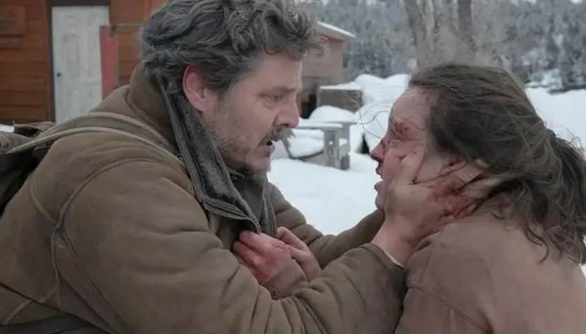 Joel w śnieżnej scenerii, z krwawymi śladami na twarzy, trzyma za podbródek rannego Ellie. To mocna scena, która pokazuje, jak ważna jest obsada w budowaniu napięcia.