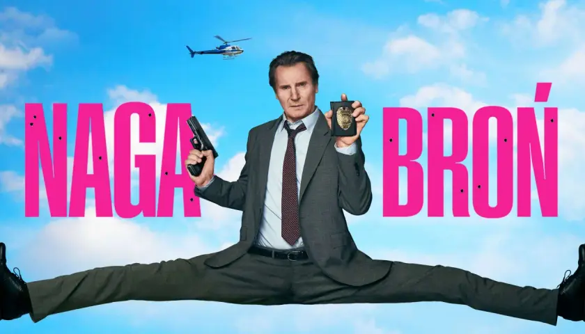Liam Neeson w filmie "Naga broń" w akcji, z pistoletem i odznaką policyjną. W tle helikopter.