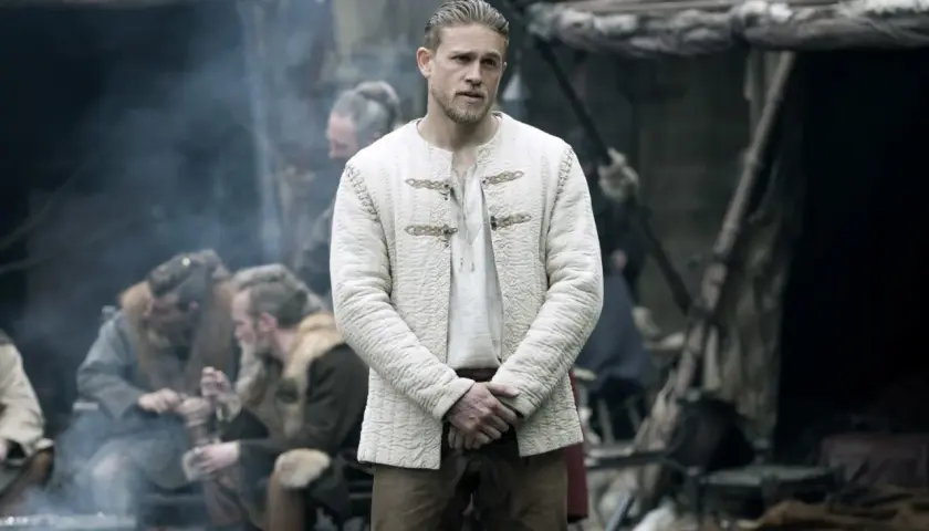 Charlie Hunnam jako Artur w filmie "Król Artur: Legenda miecza". Obsada filmu w historycznych strojach.