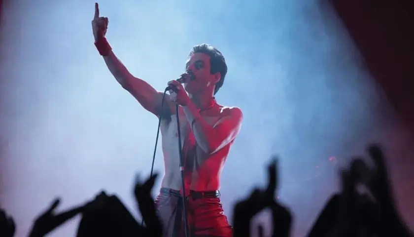 Rami Malek jako Freddie Mercury śpiewa w "Bohemian Rhapsody", porywając tłum gestem i głosem.