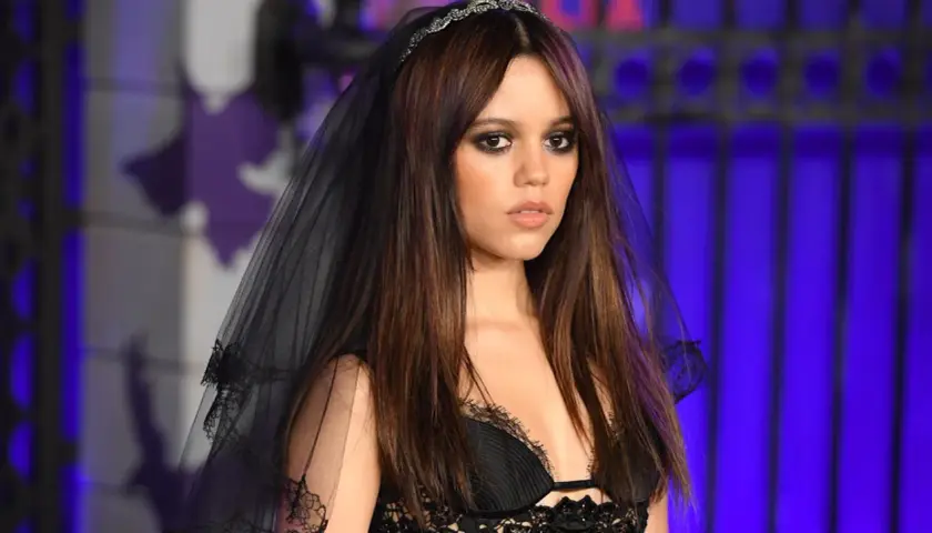 Jenna Ortega w czarnej, koronkowej sukni i welonie, z tiarą na głowie. W 2025 roku będzie miała 23 lata.