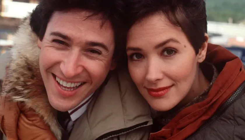 Uśmiechnięci John Cusack i Annette Bening, główni bohaterowie filmu "Przystanek Alaska", w zimowych kurtkach.