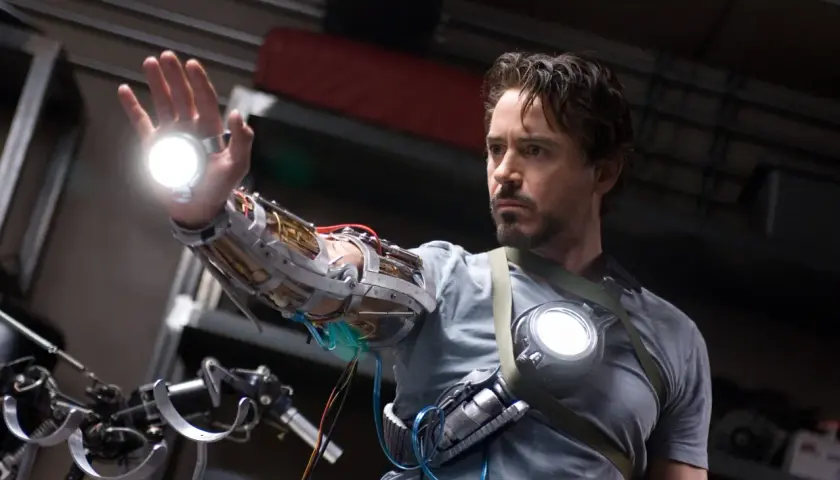 Tony Stark, w którego wciela się Robert Downey Jr. (iron man obsada), testuje nową rękawicę z repulsorami.