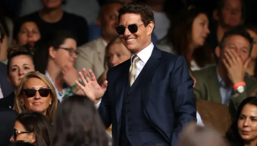 Tom Cruise w garniturze, machający do fanów. Ciekawe, ile zarabia Tom Cruise za takie wystąpienia.