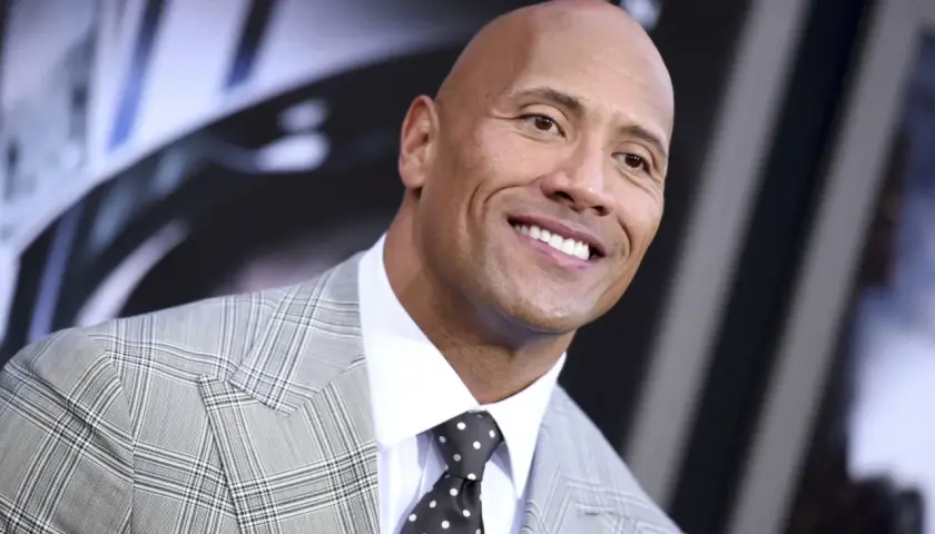 Uśmiechnięty Dwayne Johnson w garniturze. Ciekawe, ile lat ma Dwayne Johnson, patrząc na jego energię!