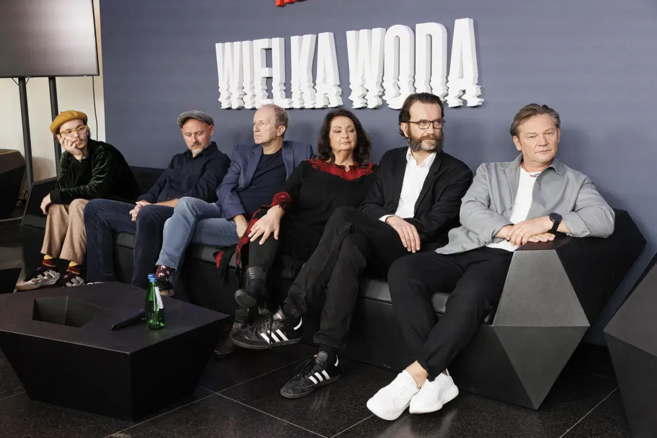 Wielka woda obsada siedzi na kanapie. W tle biały napis "WIELKA WODA".