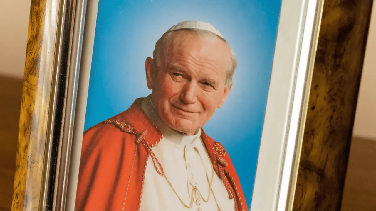 Portret Papieża Jana Pawła II w ozdobnej ramie. Kto zagrał papieża Jana Pawła II w filmie?