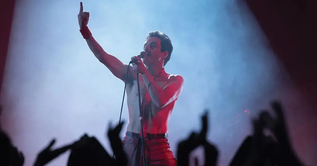 Rami Malek jako Freddie Mercury śpiewa w "Bohemian Rhapsody", porywając tłum gestem i głosem.