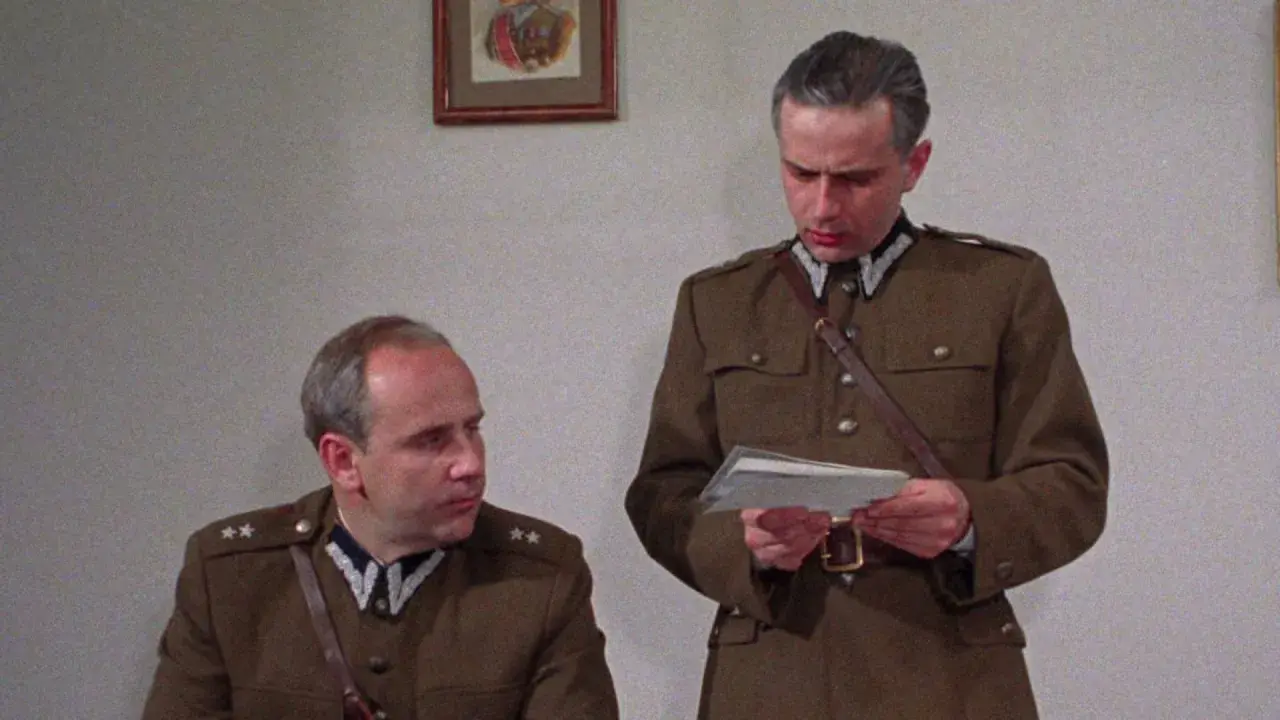 Dwóch mężczyzn w mundurach wojskowych, jeden czyta dokument. Scena z filmu "Pogranicze w ogniu obsada".