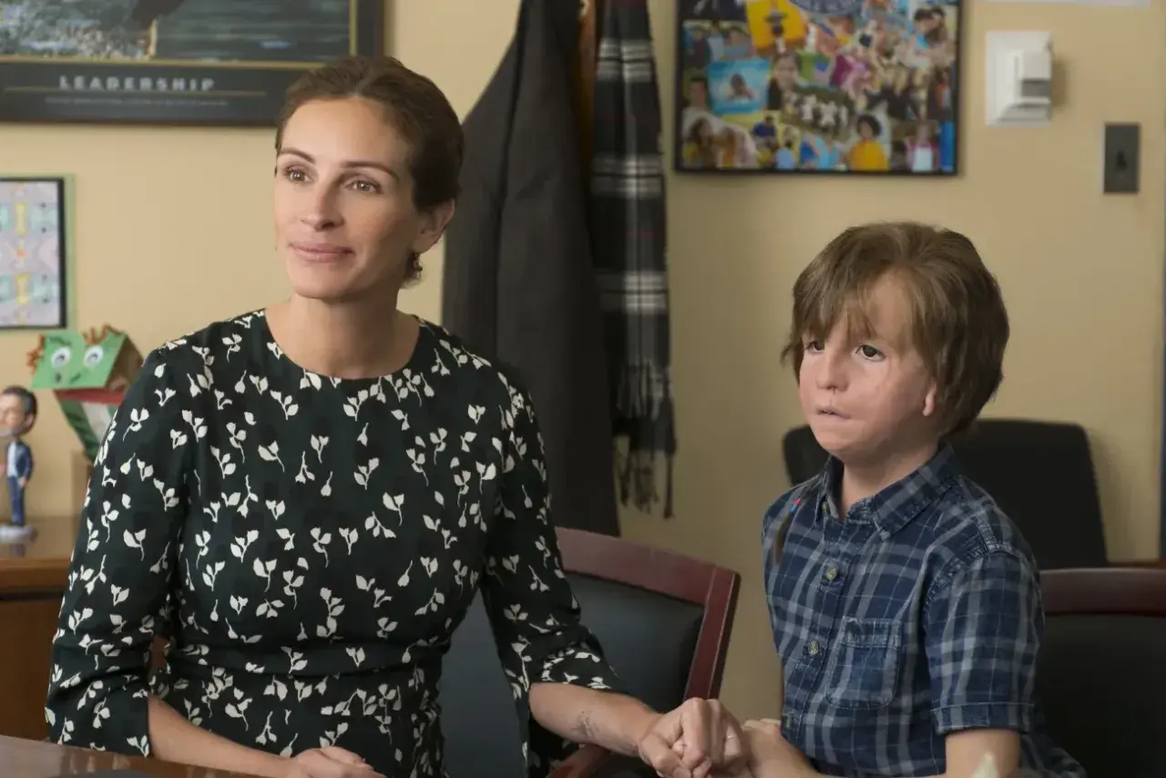 Julia Roberts i Noah Jupe jako cudowny chłopak obsada, siedzą obok siebie, trzymając się za ręce.