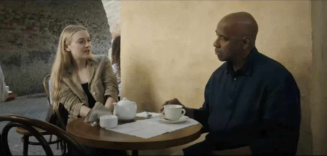 Denzel Washington i Dakota Fanning rozmawiają przy stoliku w kawiarni. To scena z filmu "Bez litości obsada".
