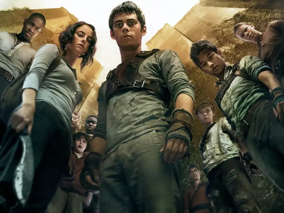 Więzień labiryntu obsada: Dylan O'Brien, Kaya Scodelario i inni młodzi bohaterowie patrzą w górę, gotowi na wyzwania.