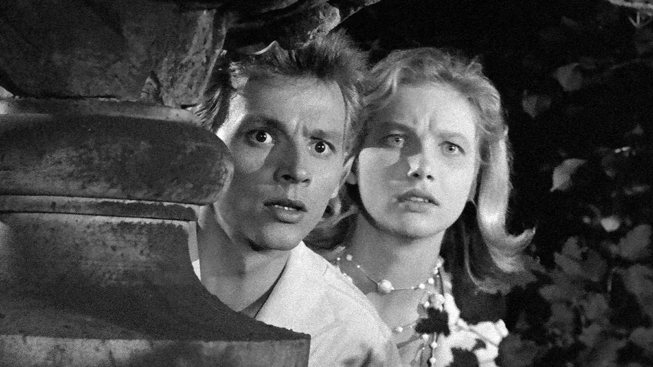 Przerażeni młodzi ludzie ukrywają się za kamiennym postumentem. To scena z filmu 
