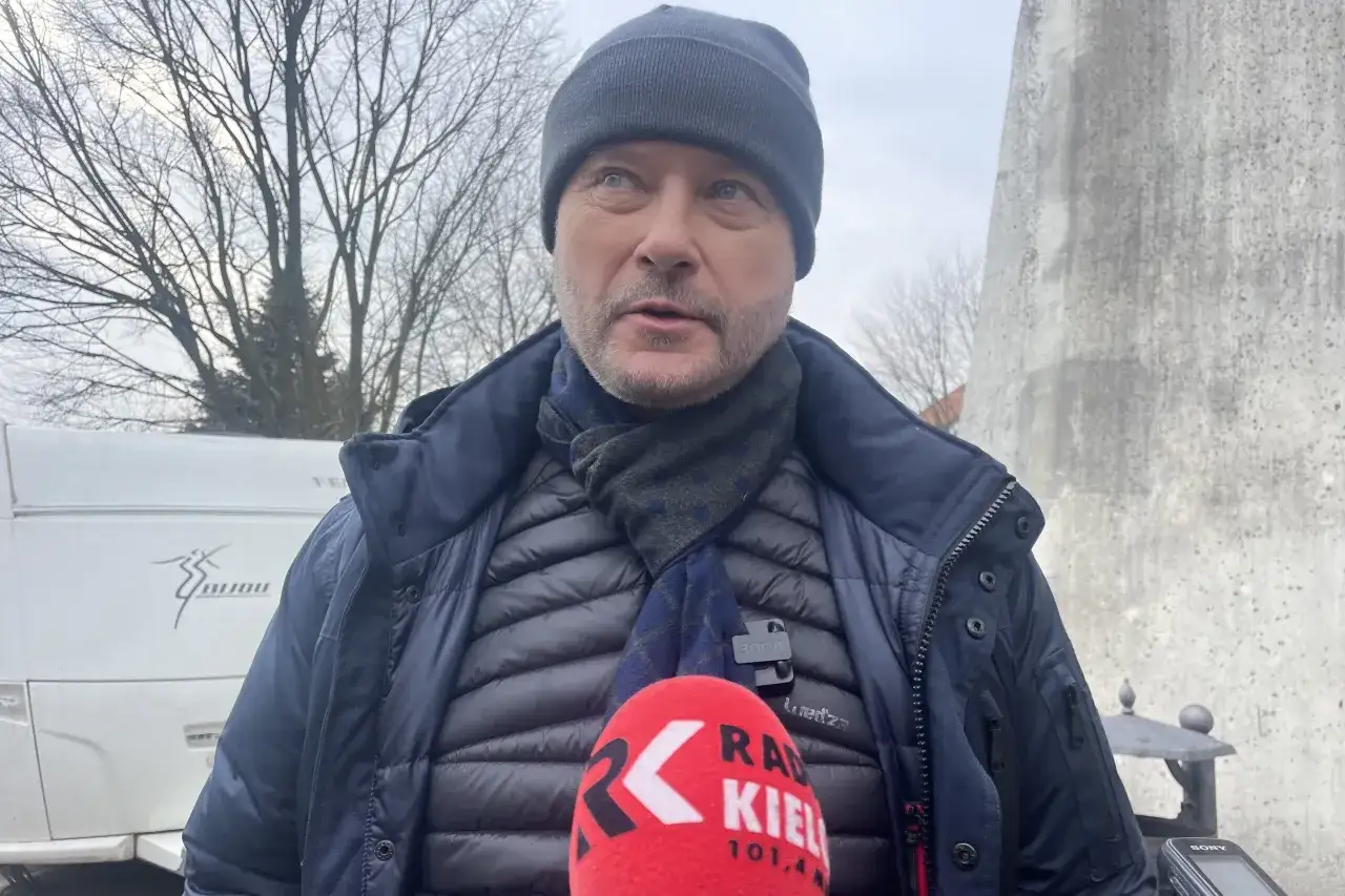 Artur Żmijewski, znany z roli księdza Mateusza, w zimowej stylizacji i z mikrofonem