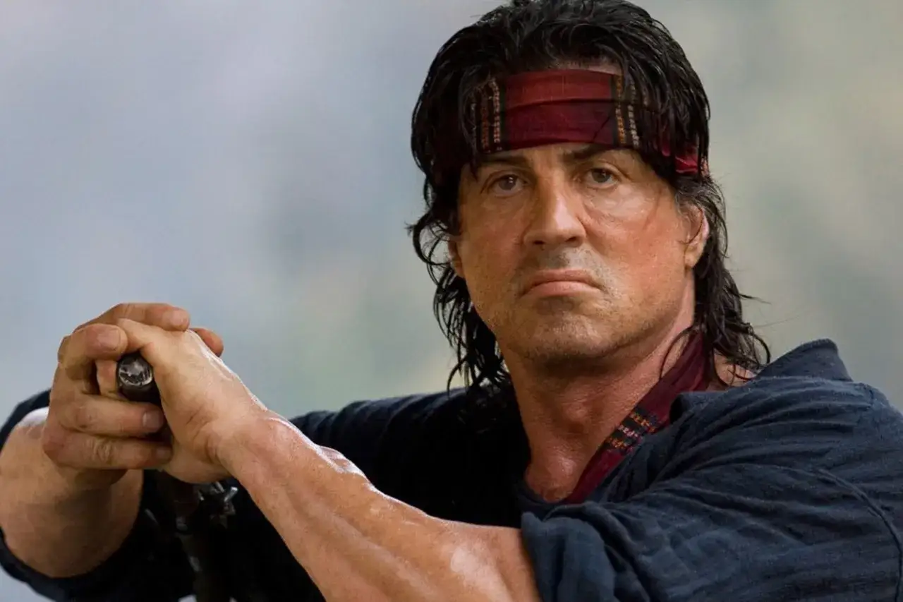 Sylvester Stallone w roli Rambo, z opaską na czole. Wciąż wygląda na silnego, mimo że ile lat ma Sylvester Stallone, to już nie jest młody.