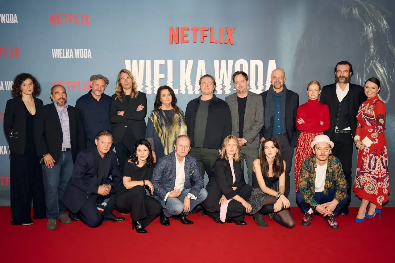 Wielka woda obsada na czerwonym dywanie. Grupa aktorów i twórców pozuje do zdjęcia przed logo Netflix.
