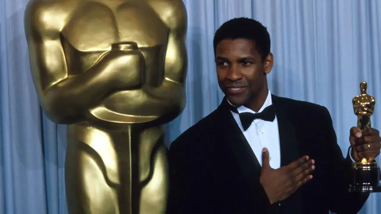 Denzel Washington z Oscarem, jednym z wielu, które zdobył. Kto ma najwięcej oscarów aktor?